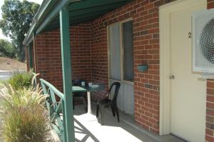 a patio with a table and chairs on a brick building at Collie Forest Motel in Collie