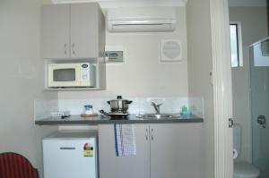 a kitchen with a white refrigerator and a microwave at Collie Forest Motel in Collie