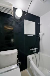a bathroom with a white toilet and a shower at HOTEL HILLARYS Akasaka in Tokyo