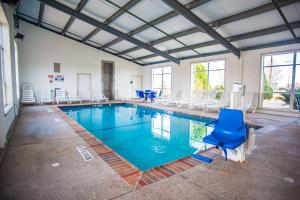 a large swimming pool with chairs and a blue chair at Motel 6-Corsicana, TX in Corsicana