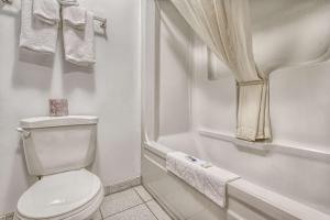 a white bathroom with a toilet and a shower at Motel 6-Windsor, ON in Windsor +22 photos