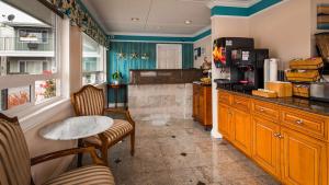 a kitchen with a counter and a table and chairs at Best Western Tradewinds in Morro Bay