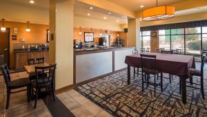 comedor y cocina con mesa y sillas en BEST WESTERN PLUS Christopher Inn and Suites, en Forney