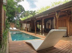 a chair sitting on a deck next to a swimming pool at Gili Joglo in Gili Trawangan