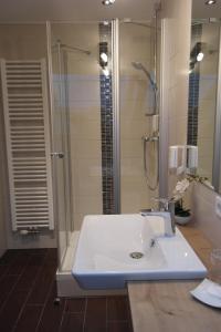 ein Badezimmer mit einem weißen Waschbecken und einer Dusche in der Unterkunft Landhotel Windlicht in Krombach + 37 Fotos