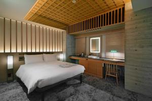 ein Schlafzimmer mit einem Bett und einem Schreibtisch sowie eine Küche in der Unterkunft HOTEL HILLARYS Akasaka in Tokio