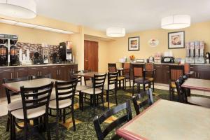 restauracja ze stołami i krzesłami oraz bar w obiekcie Super 8 by Wyndham Westminster Denver North w mieście Westminster