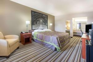 una habitación de hotel con una cama y un sofá en Super 8 by Wyndham West Monroe, en West Monroe