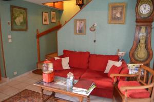 - un salon avec un canapé rouge et une table dans l'établissement Maison d'Autrefois, à Mareau-aux-Prés