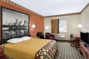a hotel room with a large bed and a tv at Super 8 by Wyndham Athens in Athens
