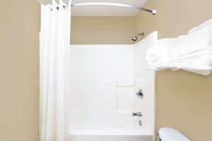 a bathroom with a shower curtain and a toilet at Super 8 by Wyndham Kosciusko in Kosciusko