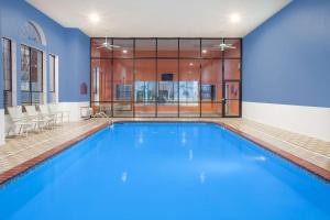 ein großer Pool mit blauem Wasser in einem Gebäude in der Unterkunft Super 8 by Wyndham White Hall in White Hall