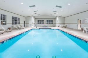 una piscina cubierta con agua azul en un edificio en Super 8 by Wyndham Hillsboro TX, en Hillsboro