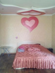 a bedroom with a bed with a heart on the wall at 2 кімн. кв. "Романтік" in Cherkasy