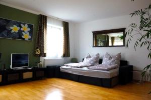 a living room with a bed and a mirror at Appartement July in Innsbruck