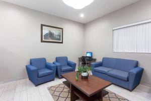 una sala de espera con sillas azules y una mesa en Super 8 by Wyndham Bakersfield South CA, en Bakersfield