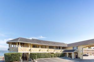 a resort building with a beach in the background at Global Inn in Coos Bay