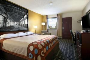 a hotel room with a large bed and a television at Super 8 by Wyndham Fox Creek in Fox Creek