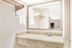 a bathroom with a sink and a mirror at Super 8 by Wyndham Corpus Christi in Corpus Christi +15 photos