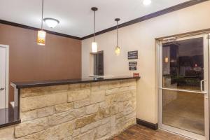 a bar in a room with a stone wall at Super 8 by Wyndham Center in Center