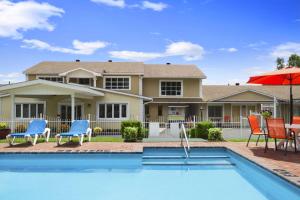 a house with a swimming pool in front of a house at Super 8 by Wyndham Brockville in Brockville