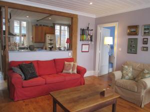 プレヌフ・ヴァル・アンドレにあるLuxury Seaside Family house in Pléneuf Val Andréのリビングルーム(赤いソファ、テーブル付)