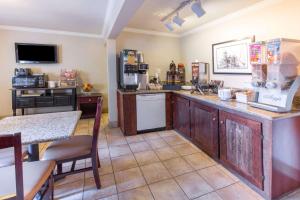 a kitchen with a counter with a refrigerator and a table at Global Inn in Coos Bay