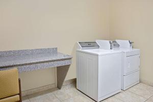 a washer and dryer in a room with a counter at Super 8 by Wyndham Intercontinental Houston TX in Humble