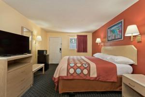 a hotel room with a bed and a flat screen tv at Super 8 by Wyndham Chipley in Chipley