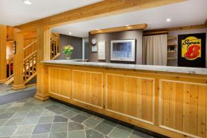 a bar in a restaurant with wood paneling at Super 8 by Wyndham Valemount in Valemount