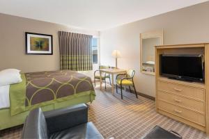 um quarto de hotel com uma cama, uma televisão e uma secretária em Super 8 by Wyndham Carroll/East em Carroll