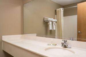 a bathroom with a sink and a large mirror at Super 8 by Wyndham Beresford in Beresford