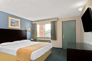 um quarto de hotel com uma cama grande e uma janela em Super 8 by Wyndham Milford/New Haven em Milford