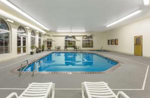 a large swimming pool with chairs around it at Super 8 by Wyndham Heyburn in Burley
