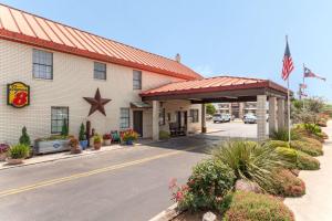 a hotel with a flag in front of a building at Super 8 by Wyndham Fredericksburg in Fredericksburg