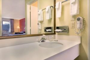 a bathroom with a sink and a mirror at Super 8 by Wyndham Lancaster in Lancaster +16 photos
