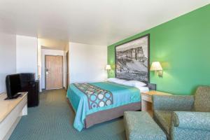 a hotel room with a bed and a tv at Super 8 by Wyndham Heyburn in Burley