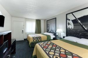 a hotel room with two beds and a flat screen tv at Super 8 by Wyndham San Diego Hotel Circle in San Diego