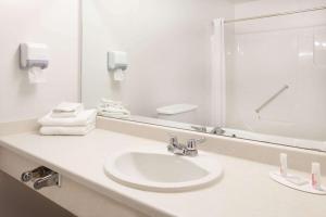 a white bathroom with a sink and a mirror at Super 8 by Wyndham Valemount in Valemount +23 photos