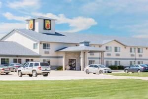 a large building with cars parked in a parking lot at Super 8 by Wyndham Carroll/East in Carroll