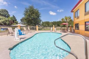 a swimming pool at a resort with tables and chairs at Super 8 by Wyndham Dublin in Dublin