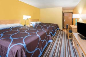 a hotel room with two beds and a flat screen tv at Super 8 by Wyndham Medina in Medina