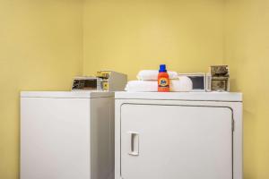 a room with two white refrigerators and a yellow wall at Super 8 by Wyndham Osseo WI in Osseo