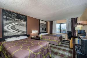 um quarto de hotel com duas camas e uma televisão em Super 8 by Wyndham Campbellsville KY em Campbellsville