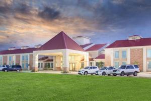 a large building with cars parked in front of it at Super 8 by Wyndham Oklahoma City in Oklahoma City
