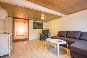 un soggiorno con un divano e un tavolo di Haus Innerdorf gemütliches Ferienhaus im Taunus a Pohl