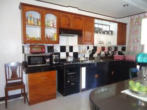 a kitchen with wooden cabinets and a stove top oven at Donsol Aguluz Homestay in Donsol