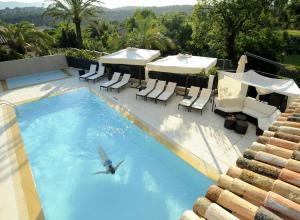 a person swimming in a swimming pool at Royal Mougins Golf, Hotel & Spa de Luxe in Mougins