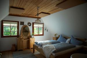una camera da letto con un letto, uno specchio e delle finestre di Jagawirt Bauernhaus a Grubberg