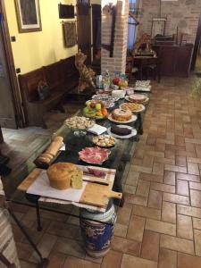 una mesa larga llena de diferentes tipos de alimentos en Il renaiolo, en Spello